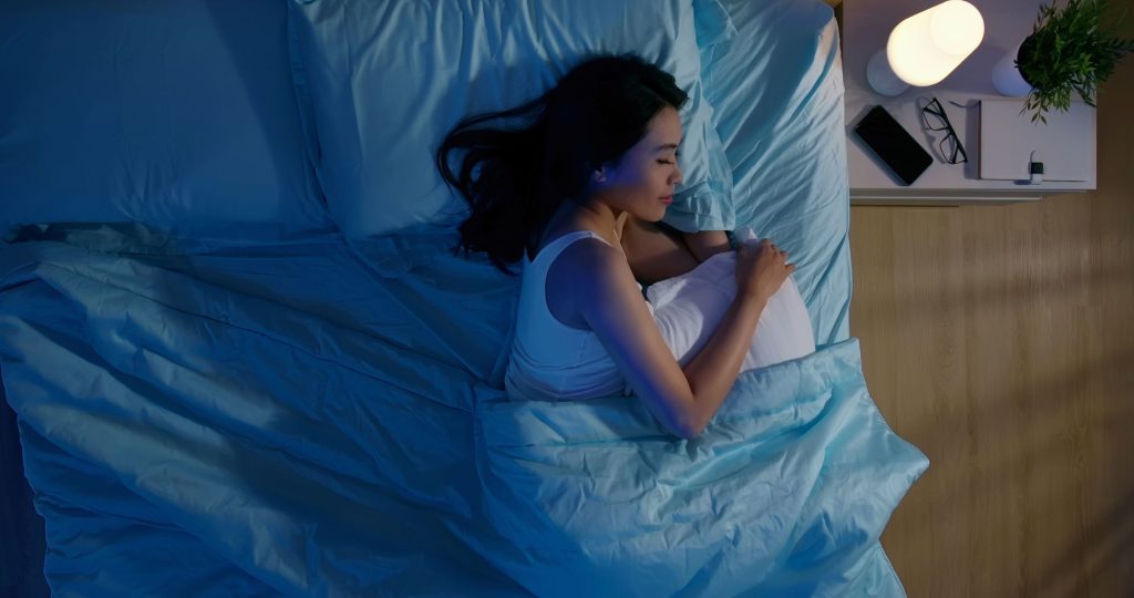 ベッドで横向きに眠る女性