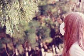木を見ているマスクをした女性