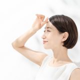 日差しを浴びて手をかざす女性