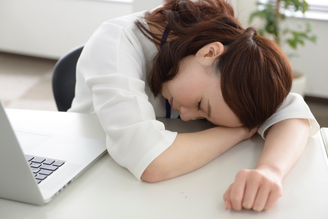 デスクで仮眠をとる女性