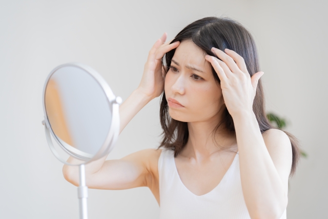 髪の毛を気にする女性