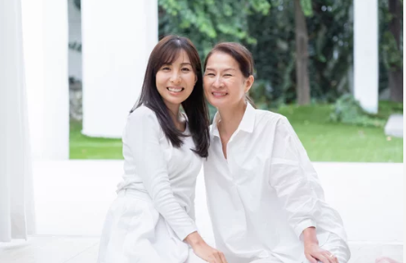 女性二人が笑顔で顔を寄せている
