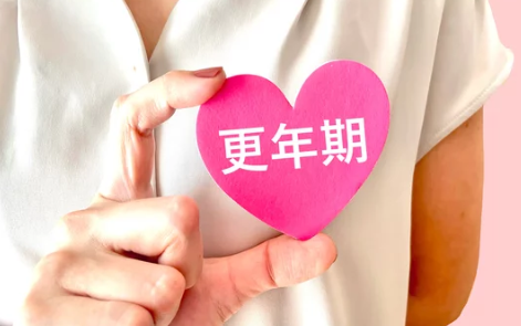 更年期の文字が書かれているカードを片手で持っている女性