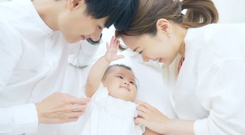 生まれたばかりの子供を見守る夫婦