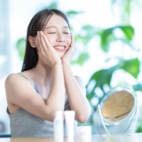 顔を両手で触れながら目をつぶっているスキンケア中の女性