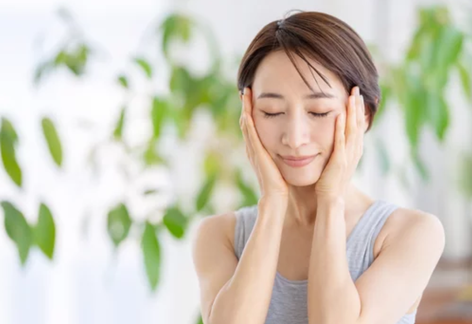両手を頬に当てる女性