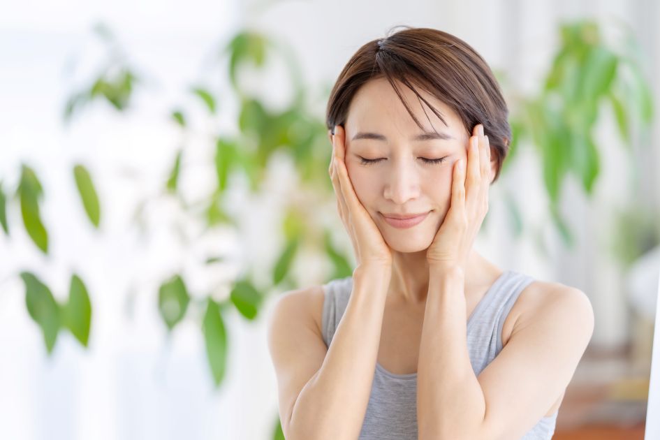 両手を頬に当てる女性