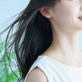 微笑む女性の髪がなびいている画像