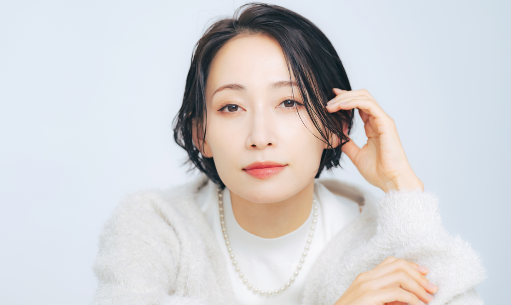 髪の毛を触るショートカットの女性