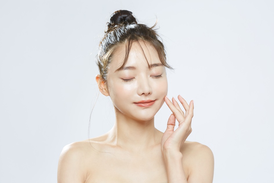 気持ちよさそうに肌に触れる女性