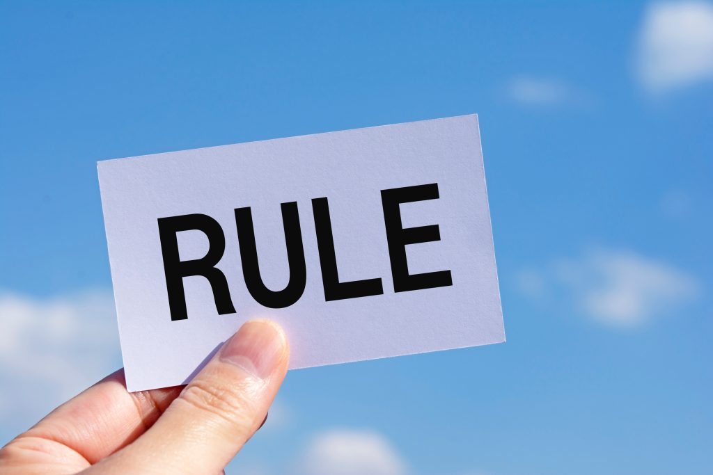 青空に「RULE」をかざす手