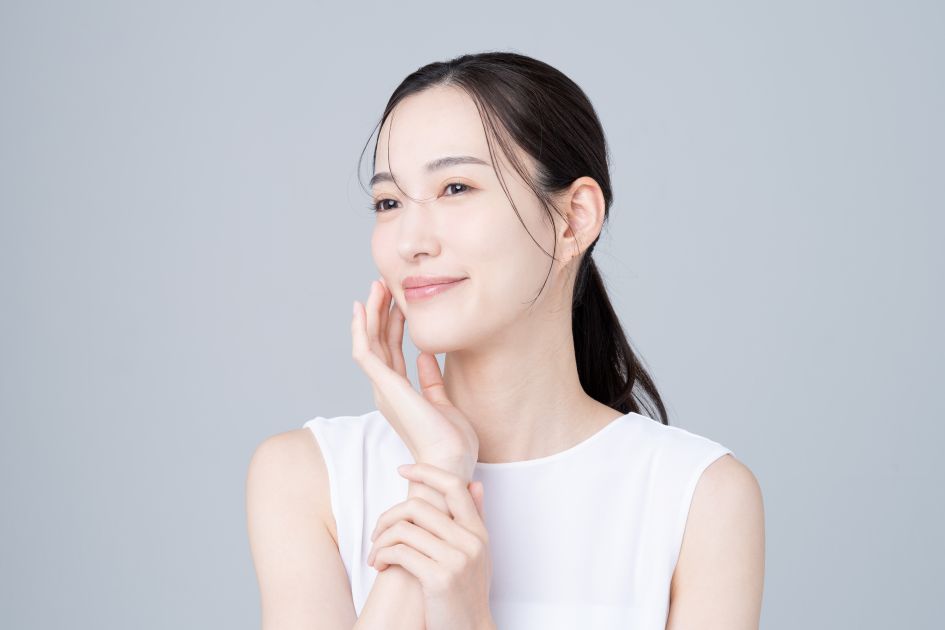 笑顔で肌に触れる女性