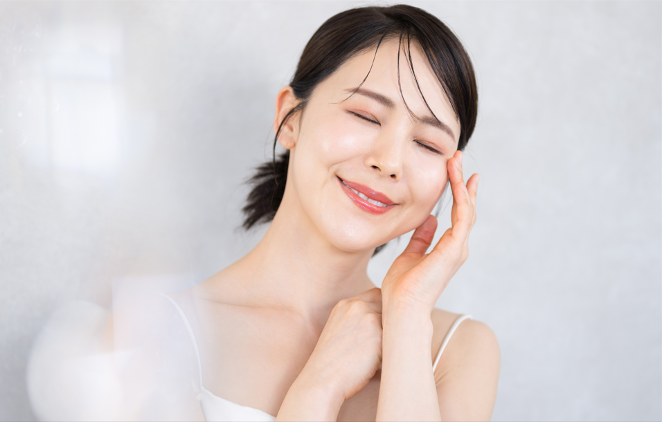 目元に触れ、微笑む女性