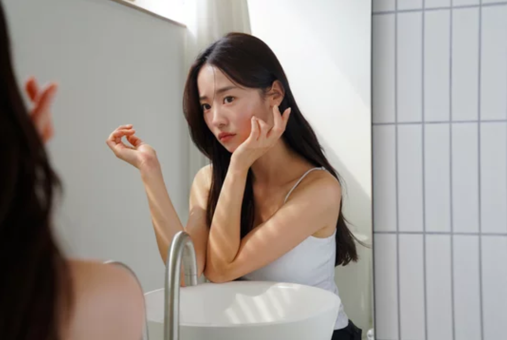 鏡を見て悩む女性