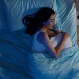 ベッドで横向きに眠る女性